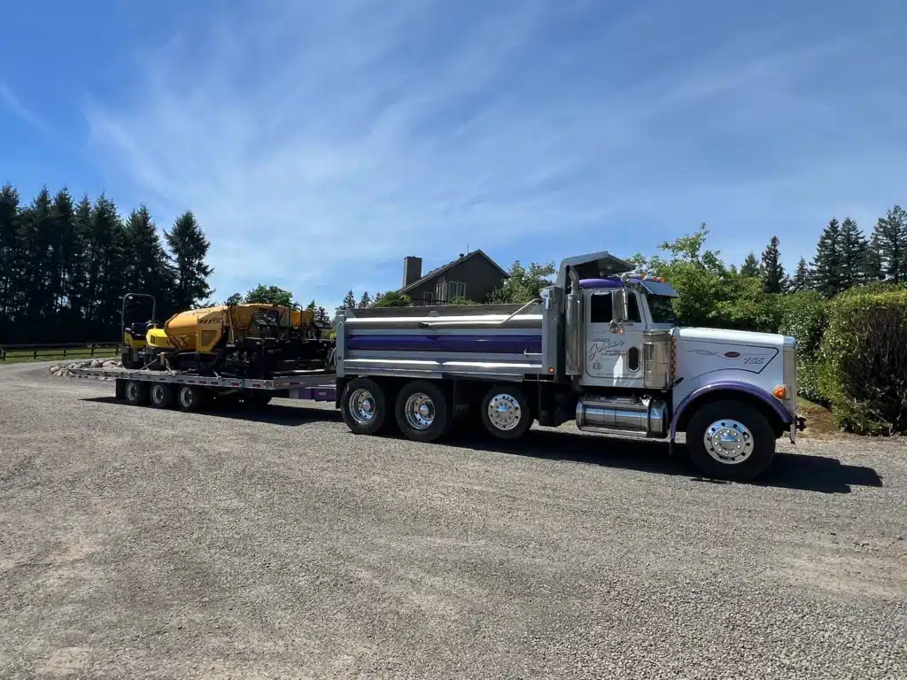 Asphalt Paving Contractor on tilt deck hooked to Dump Truck